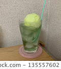 Melon soda poured into a glass with ice, melon ice cream and a pink coaster 135557602