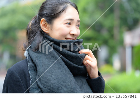 冬天,一位日本女性在城市裡圍著圍巾。 冬天,一位日本女性在城市裡圍著圍巾。 135557841