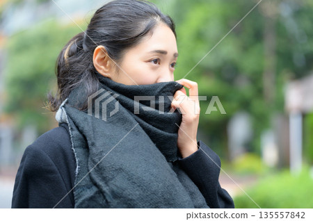 冬天,一位日本女性在城市裡圍著圍巾。 冬天,一位日本女性在城市裡圍著圍巾。 135557842