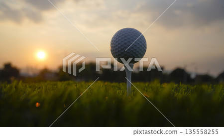 Golf ball on tee in a beautiful golf course with morning sunshine. 135558255