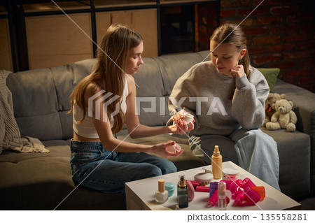 Two sisters exploring beauty products together at home. Two sisters exploring beauty products together at home. 135558281