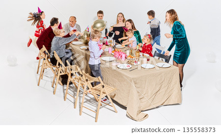 Family birthday celebration around festive table at home. 135558373