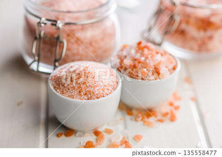 Pink Himalayan salt in bowl on white table. Pink Himalayan salt in bowl on white table. 135558477