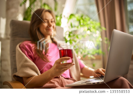 Group of young adults drinking fresh juices while working together on laptops. 135558553
