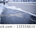 Technical salt sprinkled over asphalt road at bus stop preventing formation of ice in winter season. 135558610