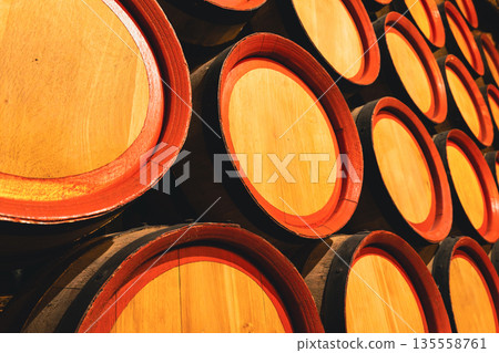 Stacked wooden barrels in a winery cellar Stacked wooden barrels in a winery cellar 135558761