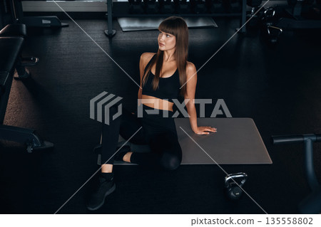 Taking a break, sitting. Young woman is in the gym Taking a break, sitting. Young woman is in the gym 135558802