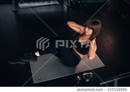 Abs exercise. Young woman is in the gym Abs exercise. Young woman is in the gym 135558806