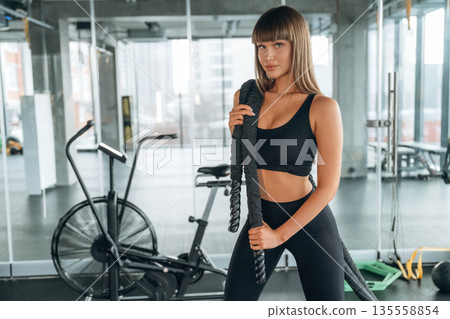 Big knot in hands on shoulder. Young woman is in the gym Big knot in hands on shoulder. Young woman is in the gym 135558854