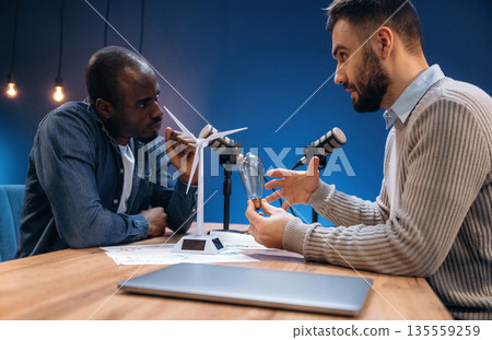Active communication. Two radio presenters recording an audio broadcast in a studio Active communication. Two radio presenters recording an audio broadcast in a studio 135559259