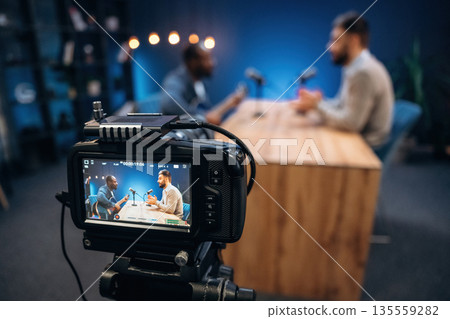 Interviewing the musician. Two radio presenters recording an audio broadcast in a studio 135559282