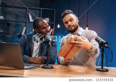 Christmas gift box. Two radio presenters recording an audio broadcast in a studio Christmas gift box. Two radio presenters recording an audio broadcast in a studio 135559316
