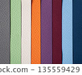 Closeup of layered print production sampler with textured paper swatches in various colors 135559429