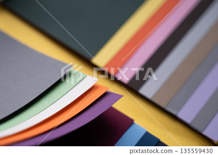 Closeup of layered print production sampler with textured paper swatches in various colors Closeup of layered print production sampler with textured paper swatches in various colors 135559430