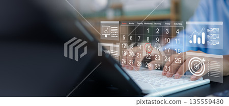 Business person hands typing on laptop with virtual calendar schedule and digital target goal icon. Time management, meeting deadline, strategic planning and organization concept. 135559480