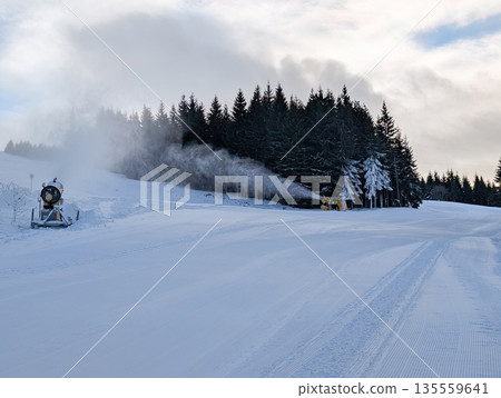 Snowmaking system operating along forested ski slope in Kopaonik. Artificial snow production, climate adaptation, and winter sport sustainability through technology and mountain infrastructure. Snowmaking system operating along forested ski slope in Kopaonik. Artificial snow production, climate adaptation, and winter sport sustainability through technology and mountain infrastructure. 135559641