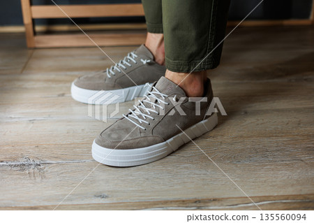 Collection of men's summer shoes. Male legs in beige leather sneakers. Men's classic shoes. 135560094