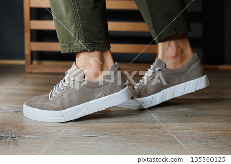 Collection of men's summer shoes. Male legs in beige leather sneakers. Men's classic shoes. Collection of men's summer shoes. Male legs in beige leather sneakers. Men's classic shoes. 135560125