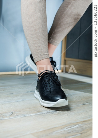Black women's sneakers. Collection of women's leather shoes. Female legs in leather black casual sneakers. Stylish women's sneakers. Black women's sneakers. Collection of women's leather shoes. Female legs in leather black casual sneakers. Stylish women's sneakers. 135560223