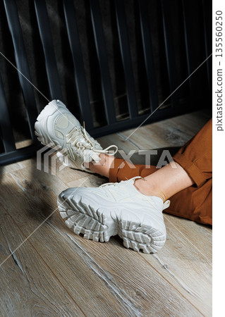 Collection of summer leather sneakers for women. Close-up of female legs in white sneakers. Women's summer sneakers with laces. Collection of summer leather sneakers for women. Close-up of female legs in white sneakers. Women's summer sneakers with laces. 135560250