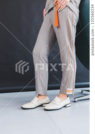 Beige women's leather shoes close-up on female legs. New collection of women's summer leather shoes. 135560334