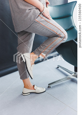 Beige women's leather shoes close-up on female legs. New collection of women's summer leather shoes. Beige women's leather shoes close-up on female legs. New collection of women's summer leather shoes. 135560400