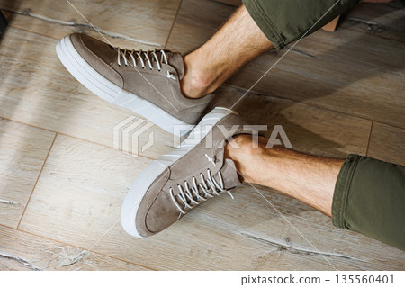 Collection of men's summer shoes. Male legs in beige leather sneakers. Men's classic shoes. Collection of men's summer shoes. Male legs in beige leather sneakers. Men's classic shoes. 135560401