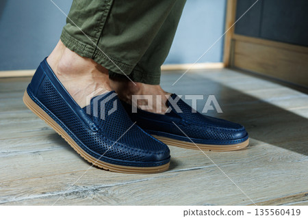 Male legs in blue leather shoes. Men's classic shoes. 135560419