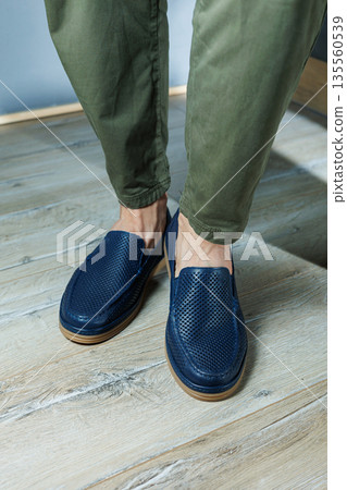 Male legs in blue leather shoes. Men's classic shoes. Male legs in blue leather shoes. Men's classic shoes. 135560539