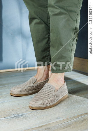 Male legs in beige leather shoes. Men's classic shoes. Male legs in beige leather shoes. Men's classic shoes. 135560544