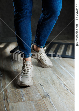 Beige women's sneakers. Collection of women's leather shoes. Female legs in leather beige casual sneakers. Stylish women's sneakers. Beige women's sneakers. Collection of women's leather shoes. Female legs in leather beige casual sneakers. Stylish women's sneakers. 135560546