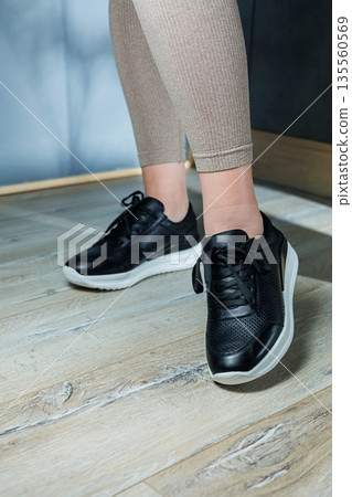 Black women's sneakers. Collection of women's leather shoes. Female legs in leather black casual sneakers. Stylish women's sneakers. Black women's sneakers. Collection of women's leather shoes. Female legs in leather black casual sneakers. Stylish women's sneakers. 135560569