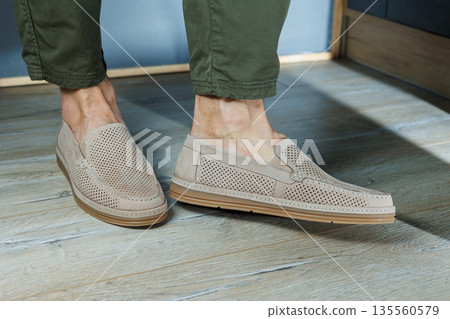 Male legs in beige leather shoes. Men's classic shoes. Male legs in beige leather shoes. Men's classic shoes. 135560579