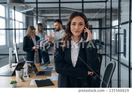 Phone call, standing. Business people are working in the office 135560829