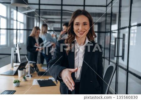 Woman is in front of her colleagues. Business people are working in the office 135560830