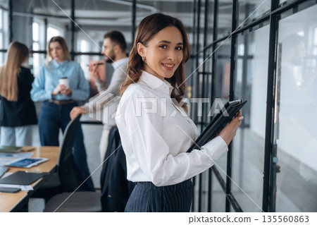 In white shirt and black pants. Business people are working in the office In white shirt and black pants. Business people are working in the office 135560863