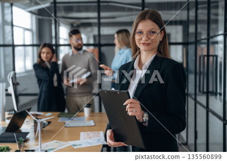 Female employee is posing. Business people are working in the office 135560899