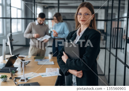 Female employee is posing. Business people are working in the office 135560901