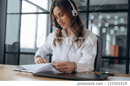 Lot of paperwork. Beautiful woman is in the office Lot of paperwork. Beautiful woman is in the office 135561419