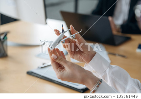 Documents and toy plane. Close up view of people in airline company 135561449