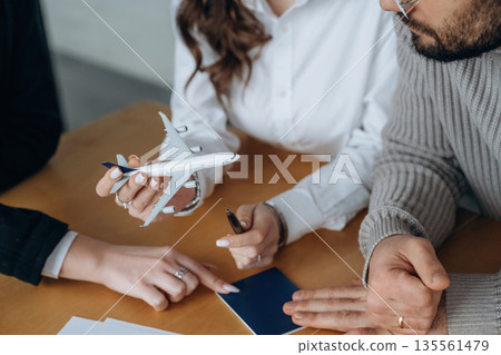 Documents and toy plane. Close up view of people in airline company Documents and toy plane. Close up view of people in airline company 135561479