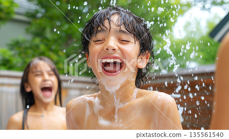 Joyful asian children enjoying water play outdoors on a summer day 135561540