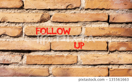 Follow up symbol. Concept word Follow up on beautiful old brown brick wall. Beautiful old brown brick wall background. Old brick wall. Business follow up concept. Copy space. 135561663