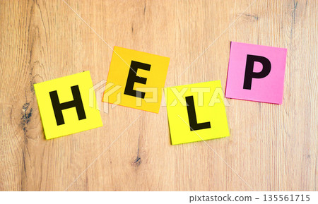 Help symbol. Concept word Help on beautiful colored paper. Beautiful wooden table wooden background. Business, lifestyle, support and help concept. Copy space. 135561715