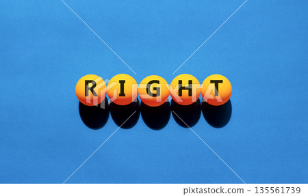 Right symbol. Concept word Right on beautiful yellow tennis ping pong balls. Beautiful wooden table wooden background. Business lifestyle right concept. Copy space. 135561739