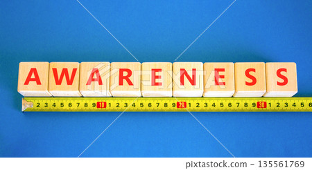 Awareness symbol. Concept word Awareness on beautiful wooden blocks. Beautiful blue background. Beautiful yellow ruler. Business education awareness concept. Copy space. 135561769