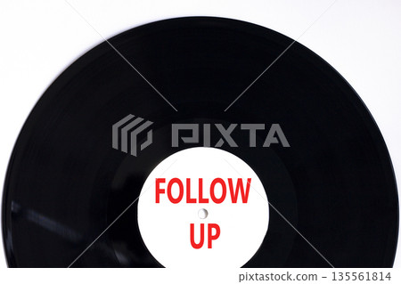 Follow up symbol. Concept word Follow up on beautiful black and white vinyl disk. Beautiful white paper background. Business follow up concept. Copy space. 135561814