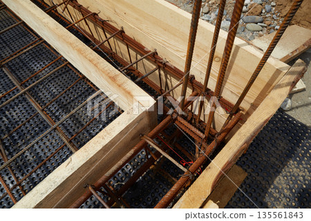 Steel reinforcement is placed in wooden molds and formwork on a construction site Steel reinforcement is placed in wooden molds and formwork on a construction site 135561843