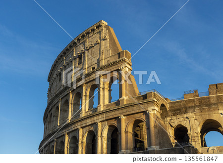Famous Coliseum in Rome. Colosseum, or Coliseum. Sunset at huge Roman amphitheatre, Rome, Italy, Europe. Famous touristic place in the world and Europe. Beautiful blue sky background. Famous Coliseum in Rome. Colosseum, or Coliseum. Sunset at huge Roman amphitheatre, Rome, Italy, Europe. Famous touristic place in the world and Europe. Beautiful blue sky background. 135561847