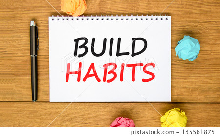 Build habits symbol. Concept word Build habits on beautiful white note. Black pen, colored paper. Beautiful wooden background. Business build habits concept. Copy space. 135561875